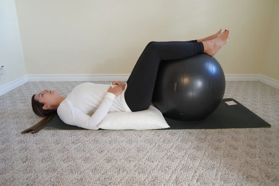 Laura lying on a yoga mat demonstrating a relaxation exercise